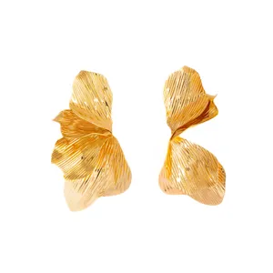 Gold abstract metal leaf earrings, exaggerated vintage stud earrings, chic statement jewelry.