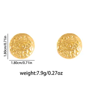 Gold vintage style metal earrings detail, detailed view showing textured eye design.