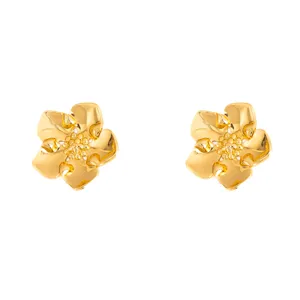 Gold metal flower stud earrings detail shot, minimalist geometric floral design jewelry.