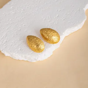 Detailed shot of textured gold drop earrings showcasing unique metallic surface design.