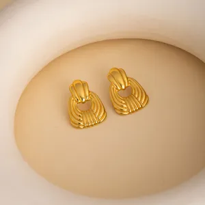 Detailed shot of retro gold geometric shell earrings, minimalist textured metal design.