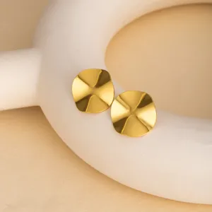 Exquisite gold wavy geometric metal stud earrings detail close up view, elegant jewelry.