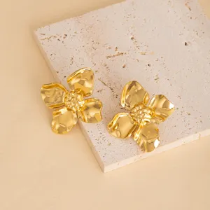 Close-up detail shot of vintage gold flower stud earrings, featuring polished metallic finish.