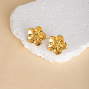 Close-up of golden metallic flower earrings featuring delicate petal details and glossy finish.