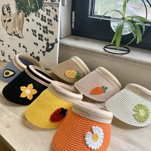 Detailaufnahme von süßen Häkel-Sonnenschirmen mit Früchten, Stroh-Leerkappe für Sommer.