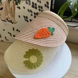Detailaufnahme der Sommer Stroh Sonnenblenden für Kinder mit Häkel Karotte und Blumen Dekor.