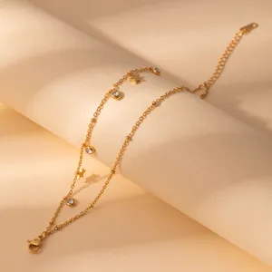 Stainless steel gold tone star crystal charm bracelet detail shot, minimalist fashion jewelry.