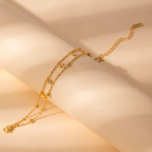 Double layer gold chain bracelet with cross pendants and sparkling rhinestone charms.