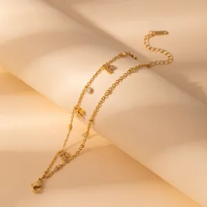 Detailed shot of double layer gold stainless steel flower charm bracelet with crystal detail.