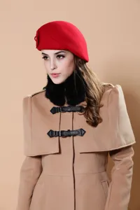 Elegant women wool beret hat matching with stylish camel cape coat and warm black faux fur collar.