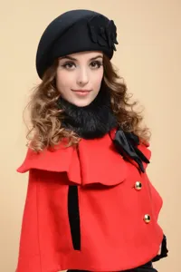 Elegant black wool beret with floral detail and stylish red cape for winter wear.