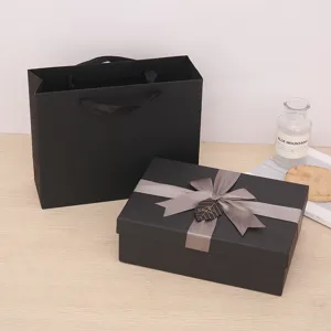 Black gift box set with grey ribbon bow and matching paper bag for birthday and holiday presents.