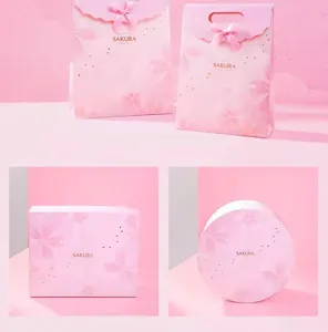 Pink cherry blossom gift bags and boxes set with elegant bows for birthday party presents.