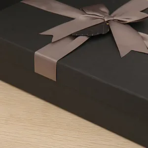 Black rectangular gift box with elegant ribbon bow for birthday and party present packing.