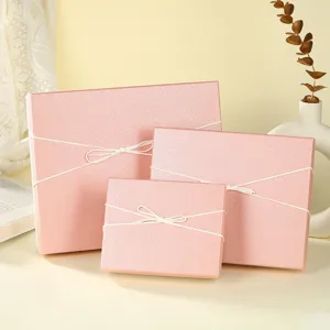 Detailed view of elegant pink gift boxes with white bow tie, premium packaging texture.