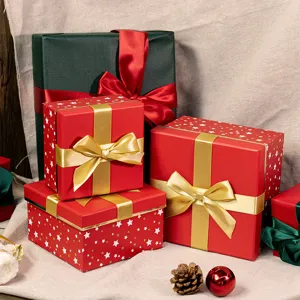 Detailed view of red and green Christmas gift boxes with bows and star patterns, elegant packaging.