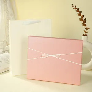 Elegant pink gift box with white ribbon bow and matching paper bag for present packaging.