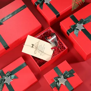 Red Christmas gift boxes with green glitter ribbons, greeting cards, and festive packaging.