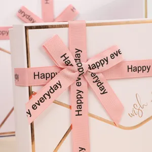 Close-up detail van luxe roze geschenkdoos met gouden rand en bedrukt lint voor cadeaus.