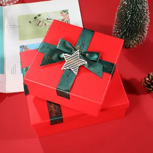 Red Christmas gift box with green glitter ribbon and star ornament, perfect for holiday packaging.