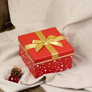 Detailed view of a square red gift box with gold bow and star pattern, elegant festive decor.