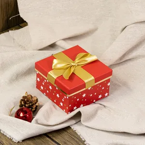 Detailed view of a red Christmas gift box with gold ribbon bow and star patterns for holiday gifts.