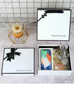 Detailed shot of minimalist white gift box with black ribbon bow and elegant love text.