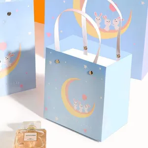 Blue gift bags with cute rabbit moon design, elegant paper packaging bags with ribbon handles.