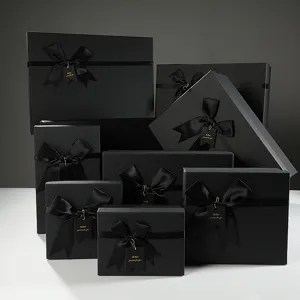 Scatole regalo nere di lusso con eleganti fiocchi in nastro ed etichette per feste e compleanni.