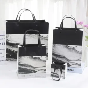 Marble pattern paper gift bags detail view, black and white luxury packaging for cosmetics.