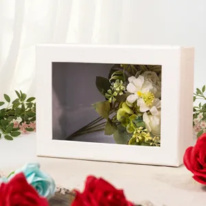 Caja de regalo blanca con ventana y flores artificiales para exhibicion creativa de cosmeticos.