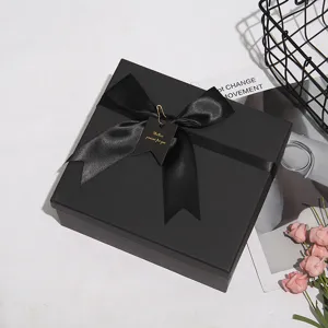Dettaglio scatola regalo nera con elegante fiocco in satin per occasioni speciali.