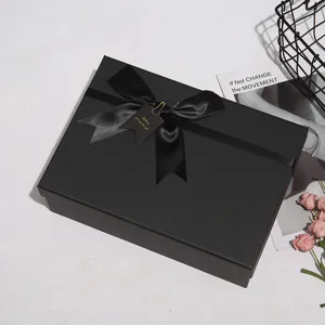 Vista dettagliata di una grande confezione regalo nera con elegante nastro e etichetta.