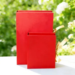Closeup detail of red cardboard gift boxes with golden ribbons, perfect for festive wrapping.