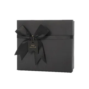 Scatola regalo nera classica con elegante fiocco in nastro, ideale per feste e compleanni.