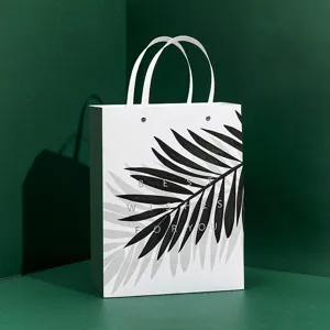 White paper gift bag with tropical palm leaf print and elegant blessing text for packaging.