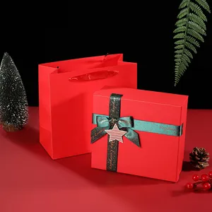 Red Christmas gift box and paper bag set with green ribbon and star decor, festive packaging.