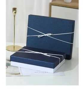 Blue gift box detail shot, showing the elegant textured surface and white ribbon.
