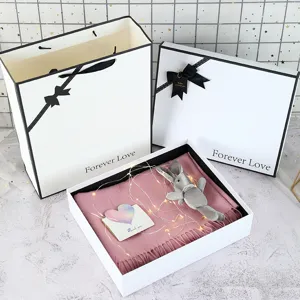 Minimalist white gift box set with bow and pink scarf, perfect for birthday and party packaging.