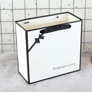 Minimalist white gift bag with black border and ribbon bow, perfect for birthday packaging.