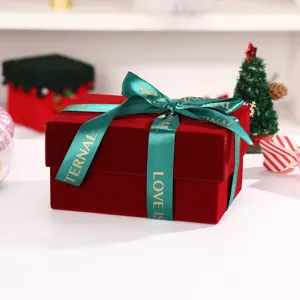 Detailed view of wine red velvet gift box with green ribbon bow for Christmas holidays.