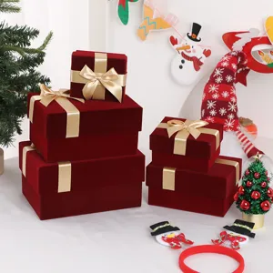 Red velvet gift box detail view showing elegant gold ribbon bow and luxury festive packaging texture.