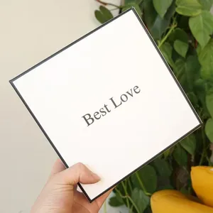 Close-up detail of a square white gift box with black borders and Best Love text print.