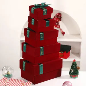 Burgundy velvet Christmas gift boxes set with green ribbon bows for holiday packaging presents.