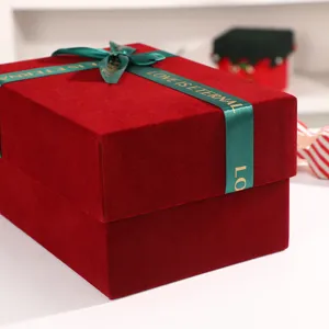 Velvet gift box detail shot, burgundy holiday packaging box with green ribbon bow.