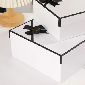Elegantly designed white gift box with black ribbon and lid base for special occasions.