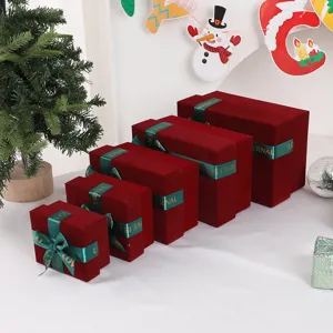 Detail view of red velvet gift boxes with green ribbon bows, perfect for holiday packaging.