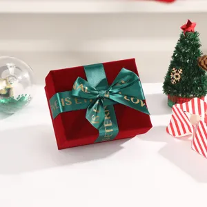 Burgundy velvet gift box with green ribbon bow, elegant holiday packaging for gifts and special day.