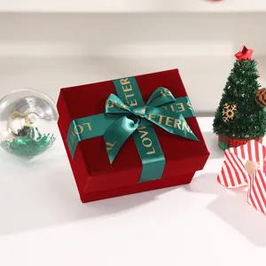 Burgundy velvet gift box with green ribbon bow, elegant packaging for holiday and wedding gifts.