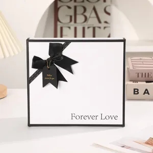 White gift box with black ribbon and bow, elegant empty packaging box for boyfriend or holiday.